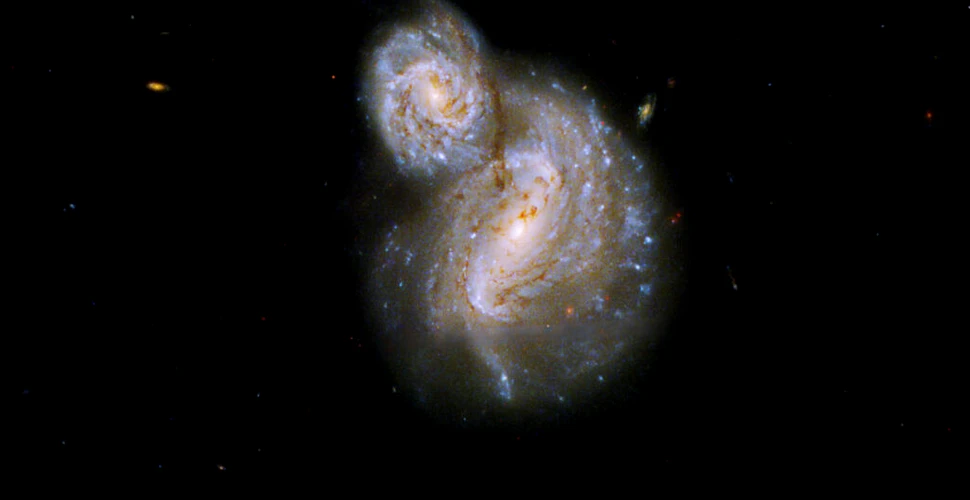 Telescopul Hubble a surprins două galaxii care se învârt una în jurul celeilalte