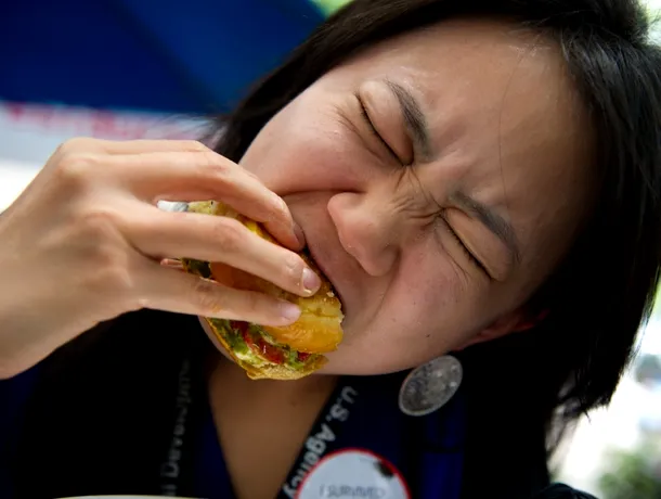 O clientă gustă dintr-un hamburger cu lăcuste
