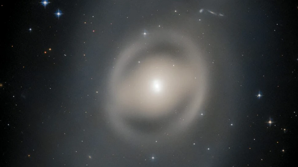 O galaxie fantomatică, observată de Telescopul Spațial Hubble în constelația Păunul