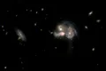Telescopul Hubble a surprins un trio spectaculos de galaxii care fuzionează