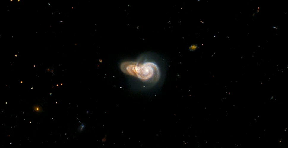 Două galaxii spiralate suprapuse, observate de Telescopul Hubble