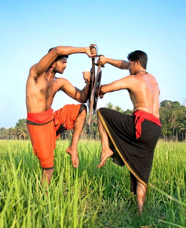 Doi practicanţi de Klaaripayattu care exersează o poatură specifică în lupta cu sabia şi scutul.