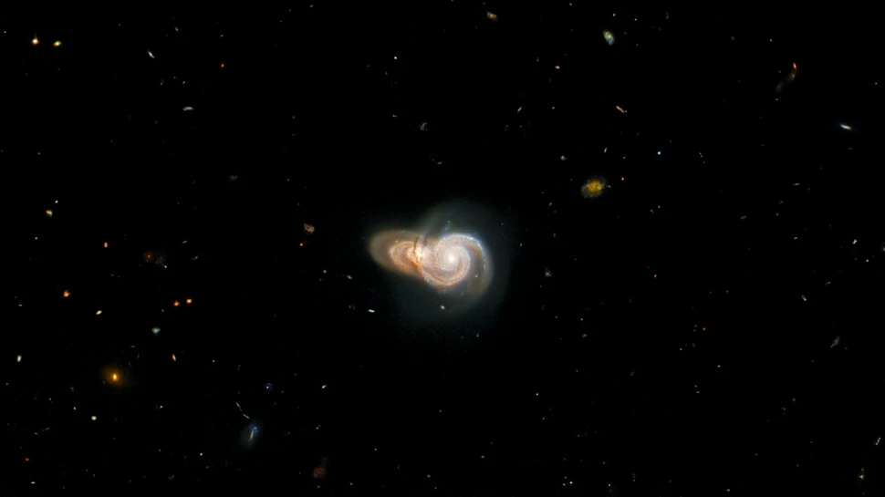 Două galaxii spiralate suprapuse, observate de Telescopul Hubble