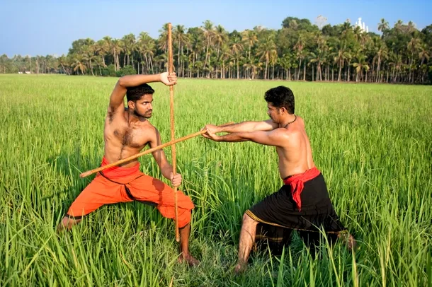 Doi practicanţi de Kalaripayattu care studiază lupta cu beţele.