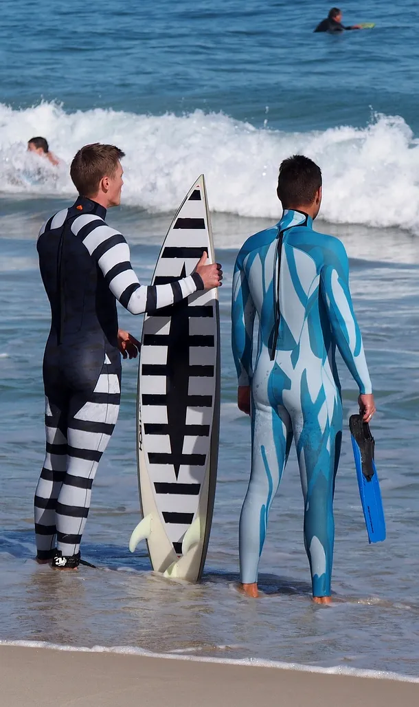 Cele două costume de baie anti-rechini şi o placă de surf cu modelul anti-rechin