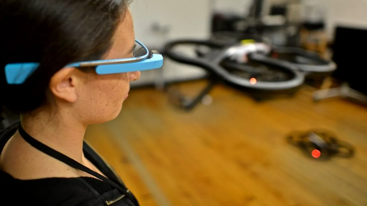 Controlling an AR Drone toy drone using Google glasses at a Nodecopter, an event where people form small groups to program toy 